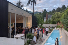 A large social gathering on the pool deck of Bonetti II during the West Coast Modern Home Tour.