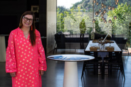 Woman stands beside table in an west coast modern home.