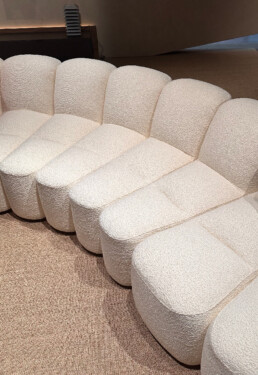 An up-close photograph of the very long modular Array sofa seating system in white fluffy material.