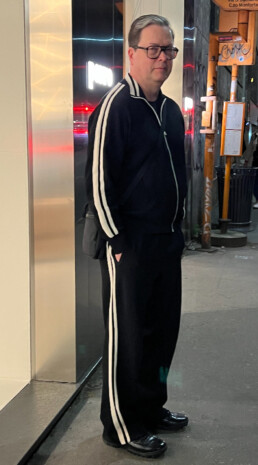 Mark Linklater in a matching pants and sweater suit stands outside of the Porro Flagship store - a closets and furniture design manufacture in Milan, Italy.