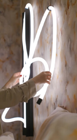 A person (only showing their hands) touches the Moooi Tubelight, moving it around showcasing it's flexibility and modular design.